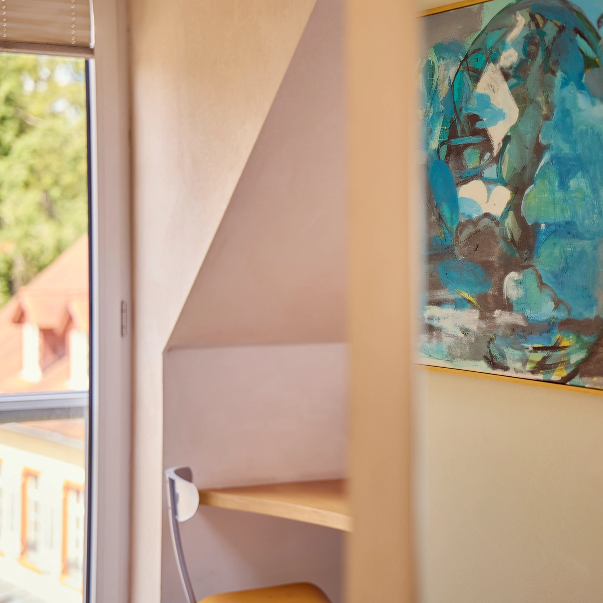 hotel-watthalden-watthaldenzimmer04 Blick in ein Watthaldenzimmer mit Arbeitsplatz, Wandbild und Fensterblick.